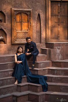 a man and woman sitting on some steps