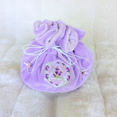 This lavender multi pocket dice bag is made with two shades of purple plush fabric. It is soft to the touch and will keep your dice nice and cozy. The embroidered design on the front features a D20 with swirling blooms of lavender surrounding it. The bag has strong cord drawstrings accented with purple butterfly charms at the ends.  Inner bag space is about 9 x 4.5 inches, plenty of room for several sets of dice, there are 6 inner pockets that will hold 3 to 4 standard dice sets and 1 large midd Purple Embroidered Bag For Gift, Dice Storage, Purple Bag, Dice Bag, Plush Fabric, Purple Butterfly, Butterfly Charm, Embroidered Design, Shades Of Purple