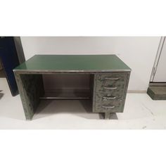 a green metal desk with drawers on it