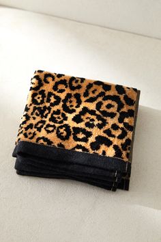 a leopard print wallet sitting on top of a white surface