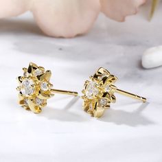 Inspired from sunflower,this pair of stud earrings shows a lovely look with its yellow gold tone. The pistil is set with a 4mm white Jeulia® Stone and six small stones decorate the petals, which make the earrings glistening flowers. They are good gifts for yourself, frinends or sisters. Never miss the little lovely thing!Carat Weight: 1.33 ctStone Size: 4,2 mmNumber of Stones: 14 Stone Shape: RoundStone Color: Diamond WhiteWeight: 2.7 gWidth: 10 mmHeight: 10.7 mmThickness: 3.6 mmMaterial: 925 Si Yellow Gold Plated Flower Earrings For Anniversary, Gold Flower-shaped Cluster Earrings With Prong Setting, Gold Flower Cluster Earrings With Prong Setting, Gold Cluster Earrings With Flower Shape, Classic Gold Flower Earrings With Cubic Zirconia, Dainty Gold Cluster Earrings For Anniversary, Delicate Gold Cluster Earrings For Anniversary, Classic Gold Cubic Zirconia Flower Earrings, Yellow Gold Flower Cluster Earrings Gift