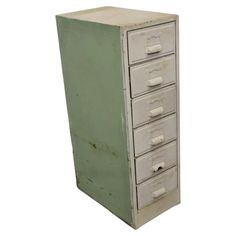 an old green and white filing cabinet with five drawers on each side, one door open