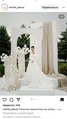 a woman in a wedding dress standing next to a white arch with flowers on it