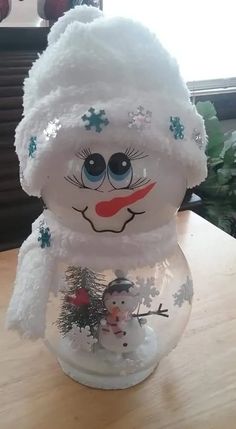 a snowman made out of plastic sitting on top of a wooden table