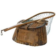 an old fishing basket with two wooden spoons and a net on the top, isolated against a white background