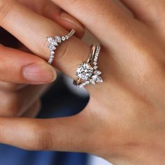 a close up of a person's hand with two rings on their fingers and one ring in the middle