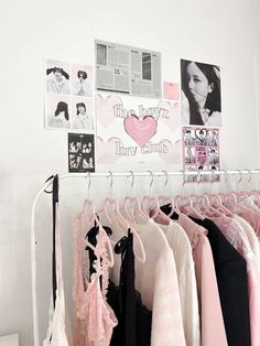 there is a rack with clothes and pictures on the wall