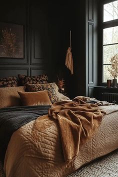 a bedroom with black walls and brown bedding