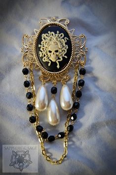 Take the plunge and make a bold fashion statement with the "Medusa" Brooch. With its captivating medusa cameo and sparkly hand-wired glass bead strands, it's the perfect accessory to give your Pirate festival look an edge. Dare to be different! 40x30mm stone, overall size is 2 inches by 4 inches Gothic Formal Jewelry Brooch, Gothic Brooch Jewelry For Parties, Gothic Party Brooch Jewelry, Metal Party Brooch, Gold Cameo Jewelry For Party, Medieval Times Dinner, Pirate Festival, Portrait Jewelry, Wired Glass