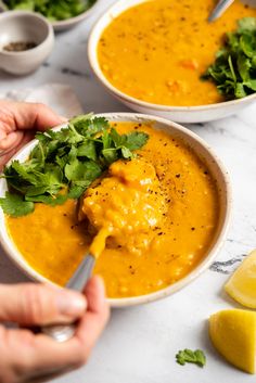 two bowls filled with soup and garnished with cilantro