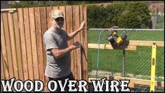 a man standing in front of a fence