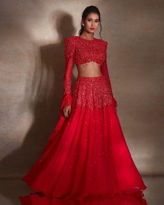 Deep vermillion georgette lehenga featuring self-pearl, glass bead & tassel embroidery paired with a power shoulder heavily embellished matching blouse with a tie back. The set comes with a ruffle organza & georgette dupatta.From Shloka Khialani's Winter Sun collection.DELIVERY TIMEPlease allow 6-8 weeks for your outfit to arrive.FABRIC DETAILSGeorgette, Net, OrganzaProfessional cleaning only. Sweetheart Blouse, Tiered Lehenga, Ruffle Dupatta, Tassel Embroidery, Cape Lehenga, Kurta Lehenga, Georgette Lehenga, Georgette Dupatta, Lehenga Skirt