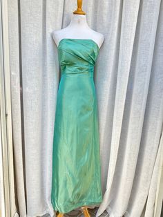 "1970's Jim Helm Occasions strapless formal dress. Made in USA. This stunning vintage dress in nice teal color features strapless style with gathered side detail. The bodice is boned for structure. Back zipper closure.  Fully lined. 100% acetate Good preowned condition. There's a small stain on the bust and few stains towards the hem (see photos ) Marked size 2. The mannequin is size 4, so I couldn't fully zip the dress. The zipper is fully functioning. Measurements (flat): Armpit to armpit: 14\" Waist: 26\" Hips: 36\" Top to hem: 51\"" 1970s Dresses Formal, Green Strapless Dress With Sweetheart Neckline And Fitted Bodice, Green Strapless Dress With Sweetheart Neckline, Summer Green Evening Dress With Ruched Bodice, Green Evening Dress With Pleated Fitted Bodice, Green Pleated Bodice Evening Dress For Cocktail, Green Cocktail Evening Dress With Pleated Bodice, Strapless Midi Dress With Lined Bodice For Evening, Green Ruched Bodice Evening Dress