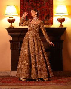 Lehenga Jacket Golden Bridal Dress Pakistani is a traditional choice to wear on the big day. This royal masterpiece is hand-embellished with resham and zardosi details, making this attire an epitome of grace and tradition. Lavish intricate designs and threads make this Pakistani Bridal Dress your foremost priority. Jacket: Bridal Jacket in the golden shade is gracefully adorned with shimmering crystals and stones. The lavish details of resham, zari, threads, and zardosi enhance the overall charm Hand Embellished Lehenga For Wedding And Transitional Seasons, Long Sleeve Hand Embellished Gown For Designer Wear, Hand Embellished Long Sleeve Gown For Designer Wear, Traditional Gown With Gold Embroidery, Hand Embellished Anarkali Gown With Long Sleeves, Traditional Gown With Resham Embroidery For Reception, Traditional Gown For Reception With Resham Embroidery, Traditional Reception Gown With Resham Embroidery, Raw Silk Gown For Reception