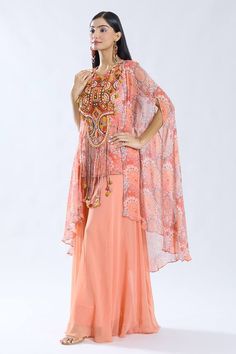 Peach asymmetric cape with floral pattern. Paired with a thread and tassel embroidered short inner kurta and sharara. - Aza Fashions Bohemian Kurta With Cape Sleeves For Eid, Bohemian Georgette Maxi Sets, Unstitched Bohemian Lehenga In Georgette, Semi-stitched Bohemian Sharara In Georgette, Bohemian Georgette Sharara For Navratri, Semi-stitched Bohemian Georgette Sharara, Bohemian Georgette Sharara For Eid, Bohemian Georgette Palazzo Set For Festive Occasions, Bohemian Semi-stitched Georgette Sharara