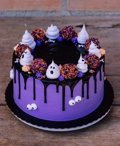 a halloween cake decorated with sprinkles and ghost faces on it's side