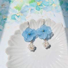 Indulge in the timeless elegance of these Resin Pressed Real Hydrangea Flower with Pearl Ball Dangling earrings, meticulously handcrafted for the discerning wearer, with option Blue, Pink and Ivory. These exquisite earrings capture the delicate beauty of botanical elegance, ideal for enhancing any occasion, especially for bridal celebrations. Handmade with meticulous attention to detail, these earrings epitomize artisanal craftsmanship and hold a unique allure. They make for an exquisite gift, s Cheap Blue Flower-shaped Earrings, Flower Decoration Drop Earrings For Summer, Elegant Flower Charm Earrings For Summer, Summer Dangle Earrings With Flower Decoration, Elegant Summer Earrings With Flower Decoration, Elegant Summer Flower Earrings As Gift, Elegant Summer Flower Earrings For Gift, Summer Wedding Dangle Flower Earrings, Elegant Summer Gift Flower Earrings