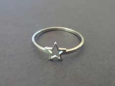 This listing is for a beautiful silver color Stainless Steel star ring. The simple ring features a classic silver color with a star outline design. This band comes in US/Canada sizes 6 through 10. Type- Ring Sub-Type- Stainless Steel Ring Style- Simple, Minimalist, Cute Size- US/Canada Sizing, 6-10 Accents- Star Outline Metal Type- Stainless Steel Color- Silver Why should you shop with Beadology By Heather? -We have a large amount of premium beads and supplies that we offer with your budget in m Cute Star Accessories, Silver Star Rings, Star Rings Jewelry, Star Ring Aesthetic, Star Ring Silver, Minimalist Silver Star Ring, Sterling Silver Star-shaped Rings, Silver Star-shaped Stackable Rings In Sterling Silver, Sterling Silver Stackable Star Rings