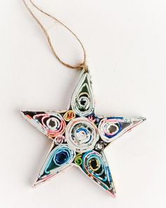 an ornament shaped like a star is hanging on a string and has multicolored spirals