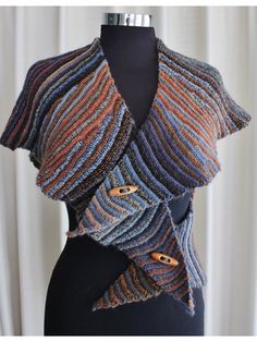 a close up of a mannequin wearing a knitted shawl with buttons