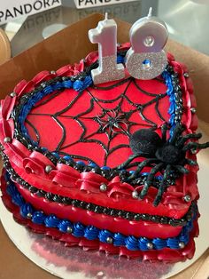 a birthday cake decorated like a spiderman with the number one on it's side