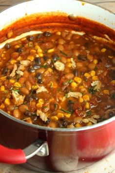 a pot filled with beans and meat on top of a stove