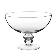 an empty glass bowl sitting on top of a white surface with no one around it