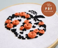 an embroidery project with black and orange flowers