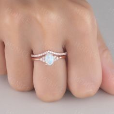 a woman's hand with a ring on it and an opal stone in the middle