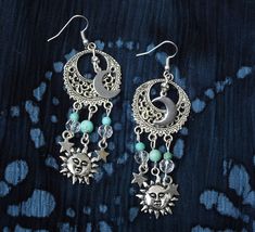 "Fun, flirty earrings with celestial charm that feature sun, half moon, and star charms swinging from filigree pendants with turquoise magnesite and glass bead accents! It's a super-cute pair of earrings to slip on to add that funky finishing touch to your outfits! And the're lightweight, too, so they're really comfortable to wear...no pulling as they swing! Choose your earwires...sterling silver or silver-plated! Sterling Silver/Silver-plated Earwires, Silver-plated Filigree Pendants 1\" round, Celestial Star Jewelry For Festival, Bohemian Star-shaped Jewelry For Festivals, Bohemian Star Jewelry For Festivals, Celestial Star-shaped Festival Jewelry, Bohemian Star-shaped Festival Jewelry, Celestial Festival Star Jewelry, Celestial Sun And Moon Dangle Jewelry, Celestial Turquoise Jewelry For Jewelry Making, Bohemian Star-shaped Earrings With Moon Charm