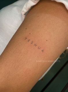 a woman's arm with the word yeshua written on it in cursive font