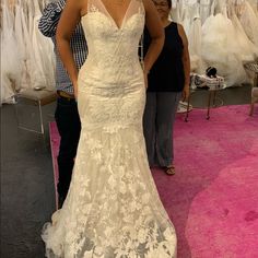 a woman standing in front of a wedding dress