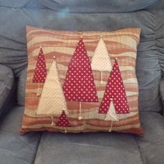 a blue couch with a red and white christmas tree pillow on it's back