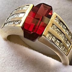 Over 6 carats of fancy cut Spessartite Garnet set in 14kt. yellow gold accented with 48 SI diamonds. One of a kind. This ring has the Wow factor.  You look at it and say Wow! The gem, diamonds and gold are all 100% genuine. The gem sits in a channel setting. The gem has rich saturation and the diamonds sparkle out loud. Perfect engagement or statement ring. Modern Multi-stone Baguette Cut Rings, Red Baguette Cut Diamond Accent Rings, Luxury Ruby Baguette Cut Jewelry, Multi-stone Diamond Baguette Cut Jewelry, Modern Multi-stone Baguette Cut Jewelry, Formal Ruby Gemstones With Accent Stones, Elegant Baguette Cut Gemstones For Anniversary, Formal Yellow Gold Jewelry With Accent Stones, Gold Emerald-cut Gemstones With Accent Stones