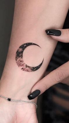 a woman's arm with a crescent tattoo on the left side of her wrist