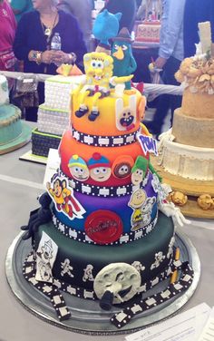 a multi layer cake with cartoon characters on it