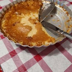 a pie in a pan on a table with utensils