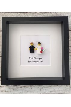 two lego figures are in a black frame