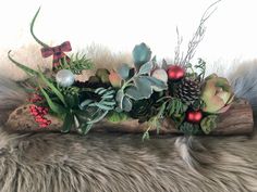 an arrangement of greenery and berries on a log