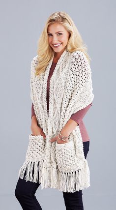 a woman wearing a white crochet cardigan with fringes on the sides