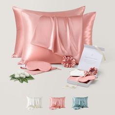 the pink satin pillow is next to its matching gift box and other decorative items on display