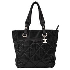 This Chanel tote bag is made of quilted nylon and is from the Spring/Summer 2007 Collection by Karl Lagerfeld. The bag features an interlocking CC Logo charm, a quilted pattern, silver-tone hardware, dual shoulder straps, protective feet at base and an interior with nylon lining. Chanel bags starting with 11XXXXXX are manufactured from 2006-2008. COLOR: Black MATERIAL: Nylon ITEM CODE: 11549000 MEASURES: H 11” x L 10” x D 4.5” DROP: 7.5” CONDITION: Good - wrinkling to exterior, scuffs or small holes at corners, pilling to handles, faint marks to exterior and interior. Made in Italy Designer Quilted Tote Shoulder Bag, Designer Quilted Bag With Double Handle, Designer Quilted Shoulder Bag For Travel, Designer Quilted Nylon Bags, Luxury Quilted Nylon Shoulder Bag, Designer Quilted Nylon Shoulder Bag, Chanel Tote Bag, Chanel Tote, Chanel Paris