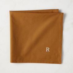 the monogrammed pocket square is made from brown wool and has a white r on it