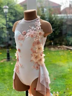 a mannequin wearing a white and pink leotard with flowers on it