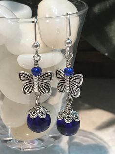 These beautiful drop earrings are meant for pierced ears. Crafted with nickel free iron fishhook ear wires, blue glass beads and silver butterflies, these are sure to please! Give as a little gift or keep for yourself! Drop length is 1 1/2 inches  color may slightly vary due to photographic lighting sources or your monitor settings Nickel-free Adjustable Butterfly Earrings, Blue Butterfly Charm Dangle Earrings, Blue Dangle Earrings With Butterfly Charm, Blue Butterfly Charm Earrings For Gift, Blue Butterfly Earrings, Silver Butterflies, Geode Necklace, Lava Bracelet, Agate Pendant Necklace