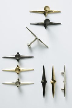 five different types of metal objects on a white surface, including one black and one gold