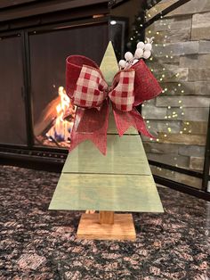 a wooden christmas tree with a bow on top