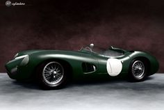 a green race car sitting on top of a cement floor in front of a dark background