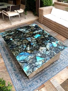 a table that is on top of a rug in the middle of a patio area