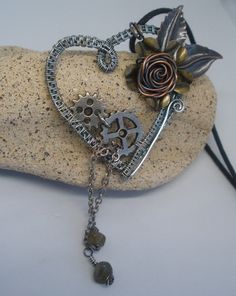 "Silver Steampunk Heart Pendant. Large Boho Necklace made with oxidised silver, cogs, leaves, flowers and handmade copper rose with chain labradorite dangles. A unique mixed metal pendant which is 4\" height from top of leaf to bottom of dangles. A real Gothic Statement piece of Jewelry ~ Comes with a 22\" black cord Great Unique gift for your Steampunk best friend Romantic present for your girlfriend on Valentine's Day Perfect accessory for you Your pendant comes in an organza bag ~ ready for gifting  Remember to Favourite ❤ my shop to see new pieces as they arrive Check out more beautiful jewelry in my shop CLICK https://www.etsy.com/uk/shop/LittleBCollectables?ref=search_shop_redirect&section_id=19778991 CARE OF YOUR HANDMADE JEWELRY  ~ store your handmade jewelry in a closed box out of Heart-shaped Silver Copper Jewelry, Silver Heart-shaped Copper Jewelry, Key Crafts, Steampunk Heart, Gift Girlfriend, Copper Rose, Necklace Heart, Handmade Copper, Girlfriend Gift